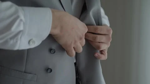 Man buttoning grey waistcoat close up Video stock 328082952