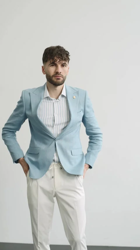 Man buttoning his blue jacket on white background in studio 動画素材 274162720