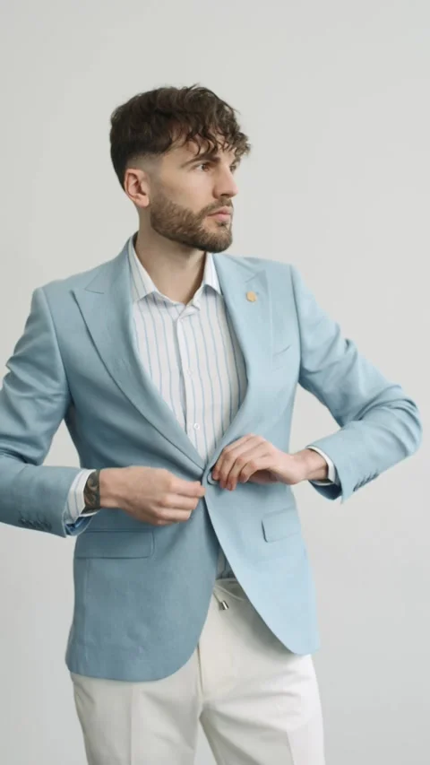 Man buttoning his blue jacket on white background in studio 動画素材 274162751