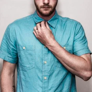 Man buttoning his shirt Stock Photos