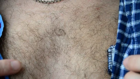 A man is buttoning a plaid shirt Stock Footage 92908697