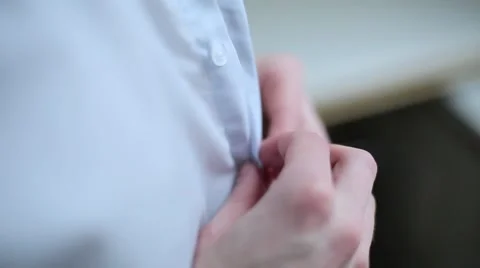 Man buttoning white shirt close up Stock Footage 64916544