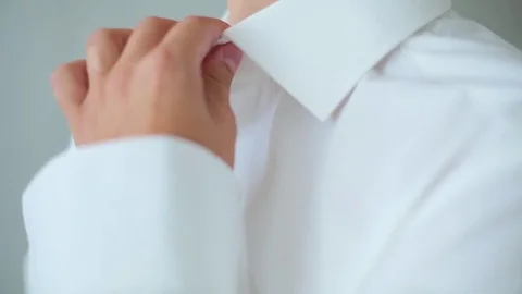 Man buttoning a white shirt Stock Footage 75618399