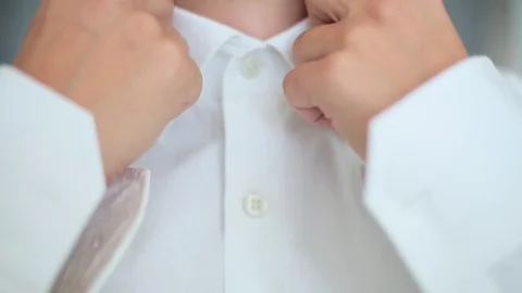 Man buttoning a white shirt Stock Footage 75618443
