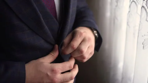 A man buttons up a beautiful jacket Stock Footage 167006684