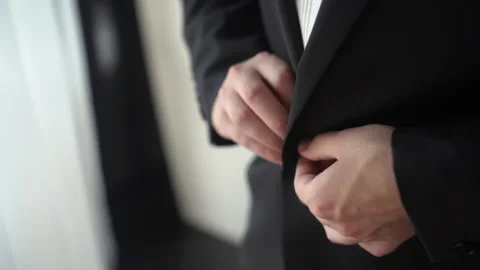 A man buttons a beautiful jacket Stock Footage 167535896