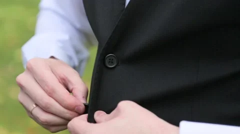 Man buttons black vest close up Stock Footage 64862096
