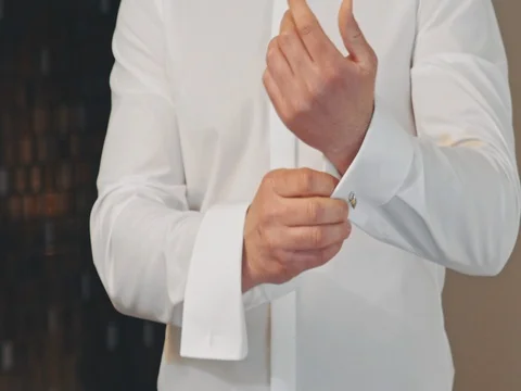 Man buttons cuff link on the shirt Stock Footage 75558914