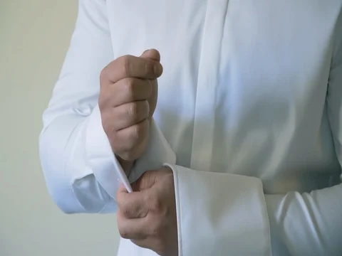 Man buttons cuff link on the shirt Stock Footage 78612043