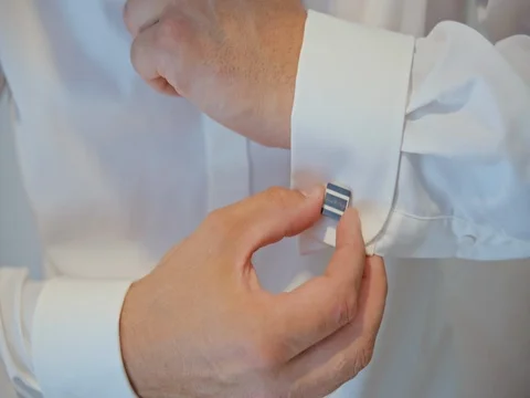 Man buttons cuff links on the sleeves Stock Footage