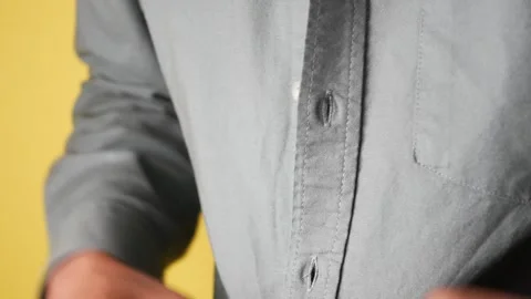 Man buttons up gray shirt in close-up motion, getting dressed for work. Stock Footage 332264029