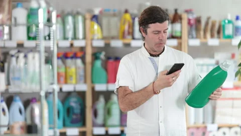 Man buyer scans qr code on liquid laundry powder label Stock Footage 310069058