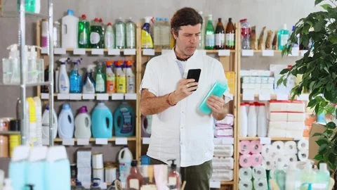Man buyer scans qr code on shower gel label Stock Footage 311837815