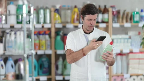 Man buyer scans qr code on dishwashing soap label Stock Footage 315028580