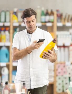Man buyer scans qr code on polish agent label Stock Photos