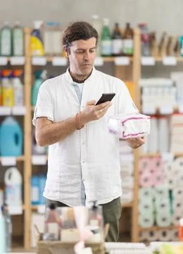 Man buyer scans qr code on panty liners label Photos