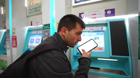 Man buying a bus ticket using a smartphone at a vending machine in China Stock Footage 336690296