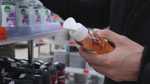 A man buys or chooses body care products in a supermarket. Stock Footage 220153544