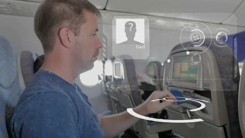 A man in the cabin with a smart device, selects a comfortable flight options Stock Footage 98855441