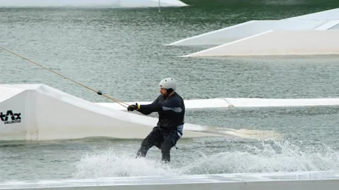 Man Cable Skiing and Wakeboarding at a Water Park in Singapore Stock-Footage 328391906