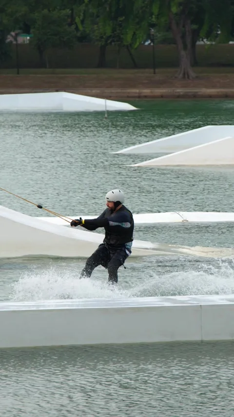 Man Cable Skiing and Wakeboarding at a Water Sports Park in Singapore Stock-Footage 328493123