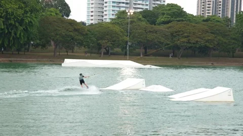 Man Cable Skiing and Wakeboarding at a Water Sports Park in Singapore Stock-Footage 328560728
