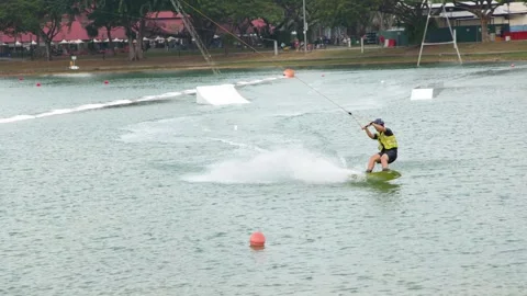 Man Cable Skiing and Wakeboarding at a Water Park in Singapore Stock-Footage 328560729