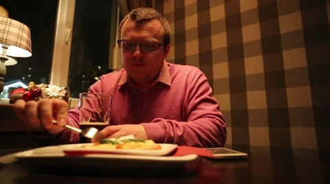 A man in a cafe drinking beer, eating and makes the photo on your phone Video stock 45805459