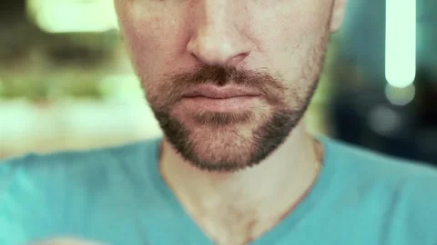 A man in a cafe, drinking coffee close - up, looking at the camera Stock Footage 99233997