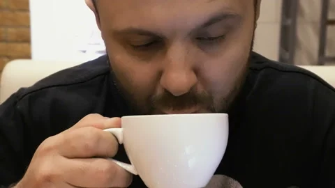 A man in a cafe drinking hot coffee. Close-up Vídeo Stock 108300789