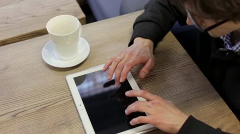 Man in a Cafe Drinking Tea and Working on Tablet Stock Footage 63863482