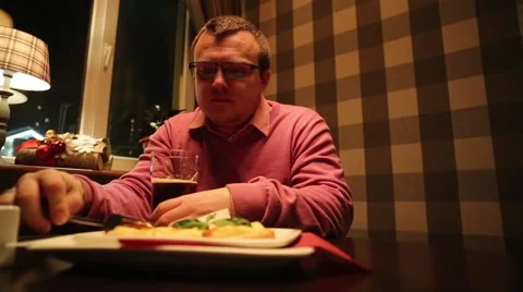A man in a cafe eating and drinking beer Stock Footage 45805652