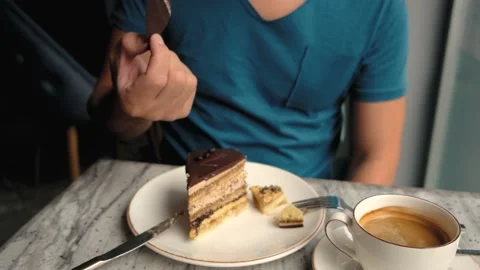 A man in a cafe eats chocolate decor from a cake Stock Footage 196286509