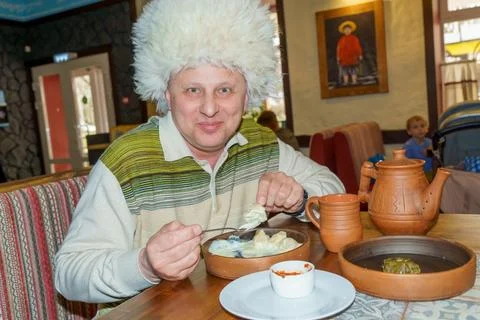 A man in a cafe eats a freshly prepared Caucasian dish. Stock Photos