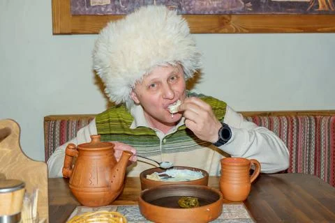 A man in a cafe eats a freshly prepared Caucasian dish. Stock Photos
