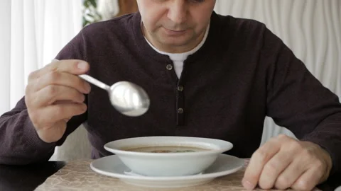 The man at the cafe table is slowly eating soup. Business lunch Video stock 105643311
