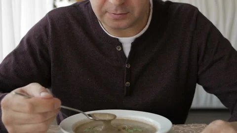 The man at the cafe table is slowly eating soup. Business lunch Video stock 105645039