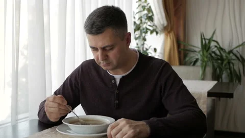 The man at the cafe table is slowly eating soup. Business lunch Video stock 105646348