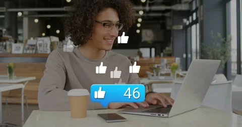 Man at cafe typing on laptop tech bubble appearing above phone tracking rising Stock Footage 329122080