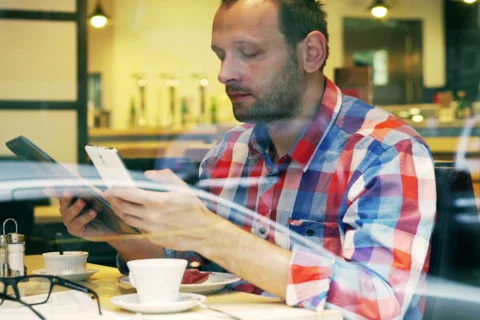 Man in the cafe using modern technology, steadycam shot Video stock 44217647