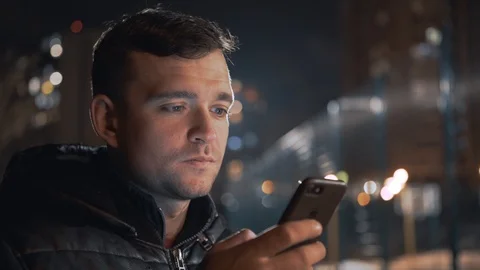 Man calling and talking on smart phone with mimic emotions smiling and sad at ni Stock Footage 102424561