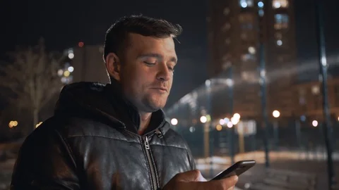 Man calling and talking on smart phone with mimic emotions smiling and sad at ni Stock Footage 102424626