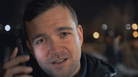 Man calling and talking on smart phone with mimic emotions smiling and sad at ni Stock Footage 102424843