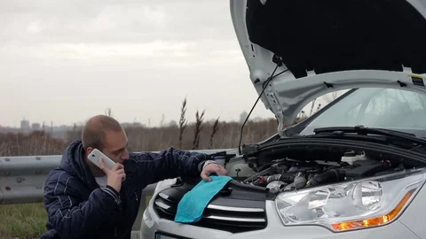 Man calling for assistance after breaking down his car. Video stock 70354427