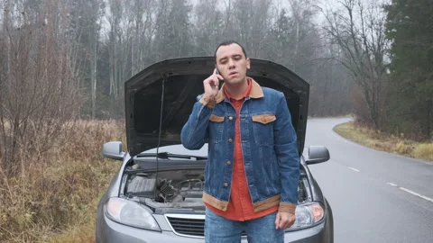 Man calling car assistance services because his car is broken.  Stock Footage 144064744