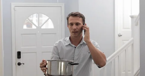 Man Calling  Emergency Plumber After Water Leak At Home Stock Footage 120893213