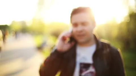Man calling on mobile Phone at Sunset in park. Blur. Out of Focus. Stock Footage 49751537