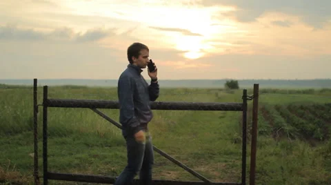 Man calling on the smart phone. Beautiful sunset on the background Stock Footage 64601015