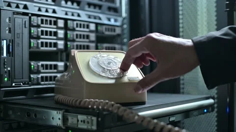Man calls on a dial phone, which stands against background of a server cabinet Stock Footage 138180589