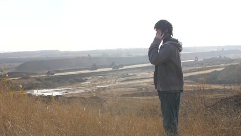 A Man Calls on the Phone Looking at the Construction of the Road. A Large Number Stock Footage 151386742